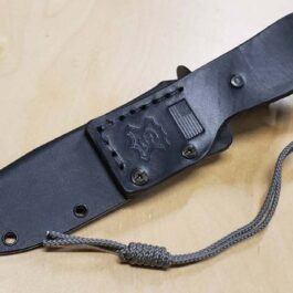 A Kydex sheath for the Chris Reeve Pacific with a cord attached to it on a table.
