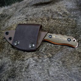 A Vertical Kydex Sheath for Benchmade Hidden Canyon Hunter laying on a fur covered surface.