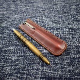 A Leather Pen Pocket Slip sitting on a blue cloth.