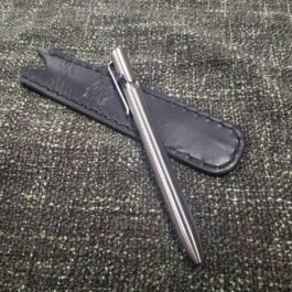 A Leather Pen Pocket Slip sitting on top of a black leather case.