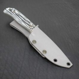 a knife with a white handle on a black surface.
