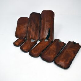a group of brown leather cases sitting on top of a white table.