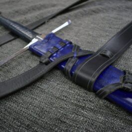 A Custom Wood Core Scabbard laying on top of a gray blanket.