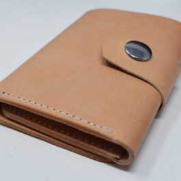 A brown leather Tri Fold Wallet with a button on it.