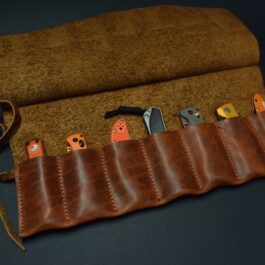 A Handmade Leather Knife/Tool Roll with scissors in it.