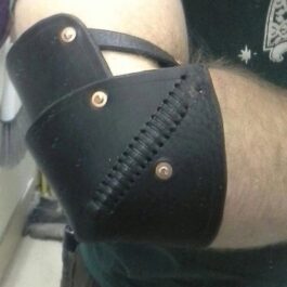 a close up of a person wearing a black leather arm brace.