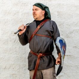 a man dressed in a medieval outfit holding The "Kevin" Wallet.
