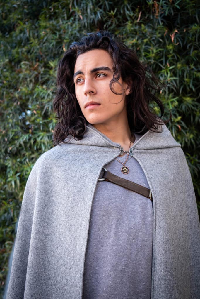 A young man dressed in a Wool Hooded Cloak.
