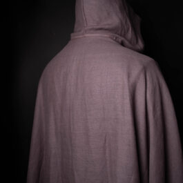 a person wearing a Wool Hooded Cloak in a dark room.