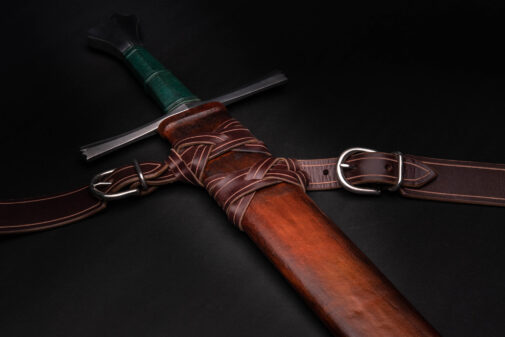 A Custom Wood Core Scabbard with a leather sheath on a black background.