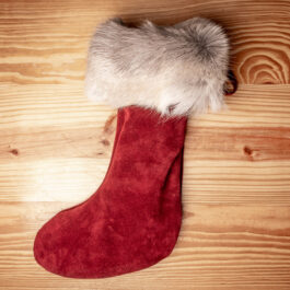a red leather christmas stocking on a wooden table