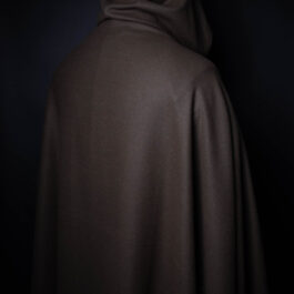 A person in a Wool Hooded Cloak in the dark.
