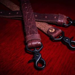 Bison Leather Suspenders sitting on top of a wooden table.