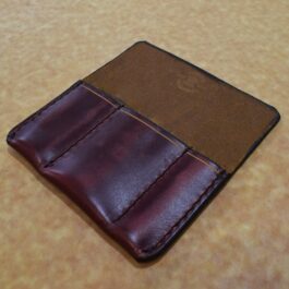 A Handmade Leather 3 Slot Pocket Organizer sitting on top of a table.