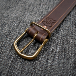A Heavy Duty Belt is laying on a gray cloth.