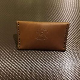 A brown leather Business Card Wallet sitting on top of a table.