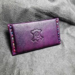 A purple Business Card Wallet sitting on top of a gray blanket.