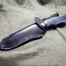 A Leather Sheath for the Benchmade Fixed Contego that is laying on a cloth.