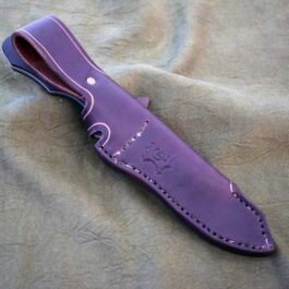 A purple leather sheath for the Benchmade Fixed Contego laying on a bed.