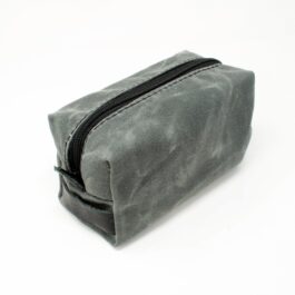 A Canvas Dopp Kit/Toiletry Bag sitting on top of a white table.