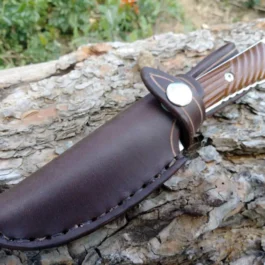 a Chris Reeve Nyala knife with a Vertical Leather Sheath in brown on a rock.