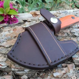 A brown Leather Scout Sheath for the Benchmade Nestucca Cleaver sitting on top of a rock.