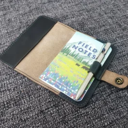 A Leather Field Notes Cover with a book on top of it.
