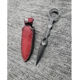 a pair of scissors sitting next to a Handmade leather Sheath for the Benchmade SOCP Dagger.