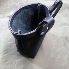 A Bison leather Dump Bag with a handle on a table.
