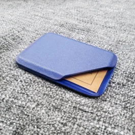 A blue Kydex wallet sitting on top of a gray carpet.