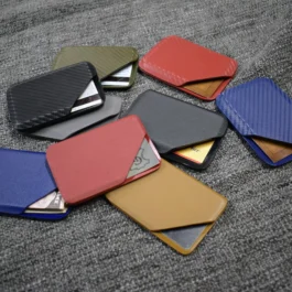 A pile of different colored Kydex wallets sitting on top of a carpet.