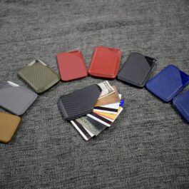 A group of different colored Kydex wallets sitting on top of a bed.