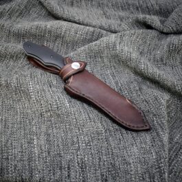 A Leather Sheath for the Benchmade Fixed Contego laying on top of a gray cloth.