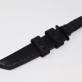 A black leather sheath for the Ka Bar Tanto Fighting Knife on a white surface.