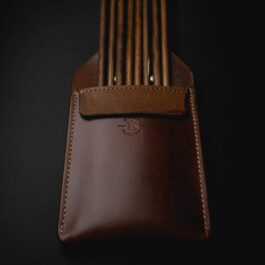 A brown Leather Pocket Quiver with a wooden handle.