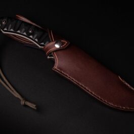 A TOPs Longhorn Bowie with a Handmade Leather Sheath on a black background.