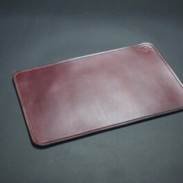 A Handmade Leather Mouse Pad on a black surface.