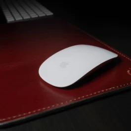 A computer mouse sitting on top of a Handmade Leather Mouse Pad.