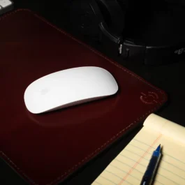 A Handmade Leather Mouse Pad sitting under a computer mouse.