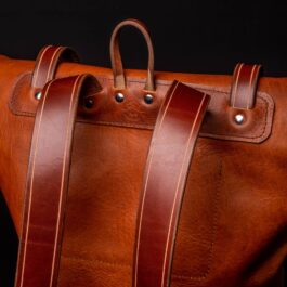 A Bison Leather Roll Top Rucksack on a black background.