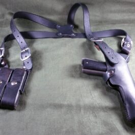 A Shoulder Holster For Full Size 1911 laying on a bed.