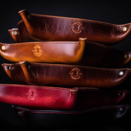 A stack of Handmade Leather Valet Trays sitting on top of each other.