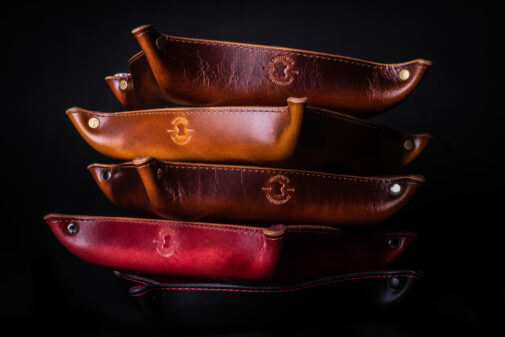 A stack of Handmade Leather Valet Trays sitting on top of each other.