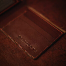 An ID Slot leather Bifold Wallet sitting on top of a table.