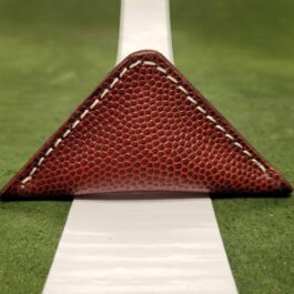 A close up of a NFL Leather Finger Football on a white line.