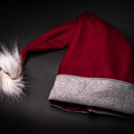 a red and grey Fleece Hooded Cloak with a white feather.