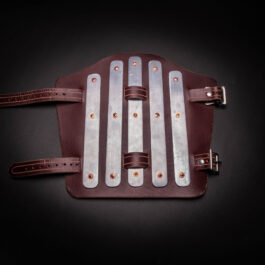 a brown and white leather Splinted Vambraces on a black background.