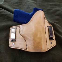 A handmade leather inside the waistband holster with a blue clip.