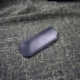 A black Foldover Slip laying on top of a green cloth.