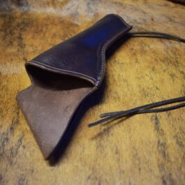 A Crossdraw Gunslinger Holster sitting on top of a wooden table.